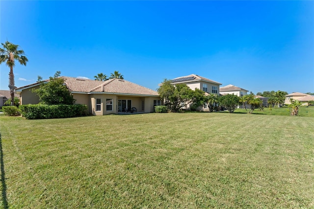 rear view of property featuring a lawn