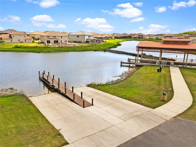 view of dock with a yard, a gazebo, and a water view