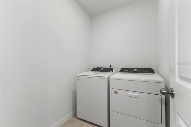 laundry room with washing machine and clothes dryer and light tile patterned floors