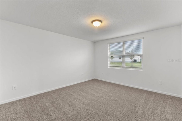 carpeted empty room with a textured ceiling