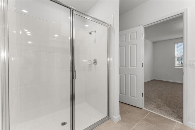 bathroom featuring a shower with door and tile patterned floors