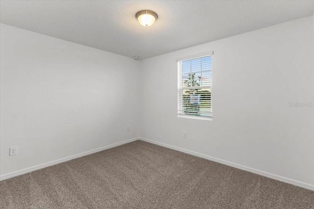 carpeted empty room with a textured ceiling