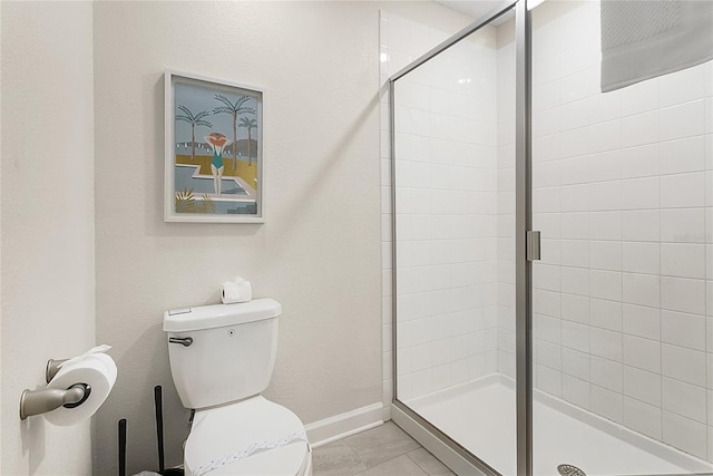 bathroom featuring tile flooring, toilet, and a shower with door