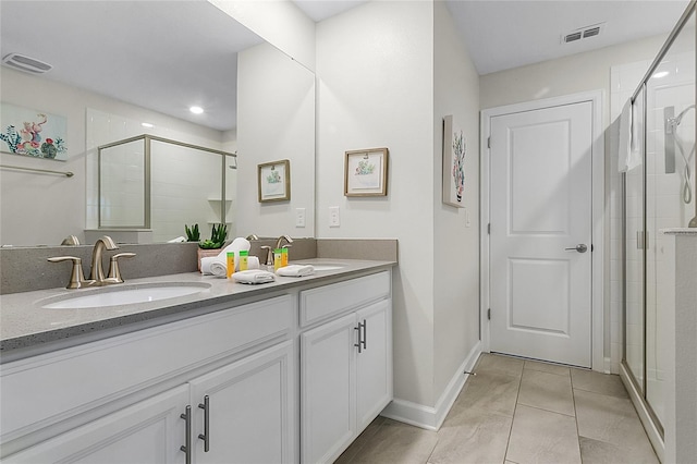 bathroom featuring double sink, an enclosed shower, oversized vanity, and tile floors