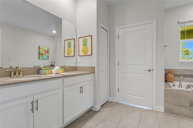 bathroom with double vanity, tiled tub, and tile floors