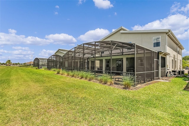 rear view of house with a lanai and a lawn