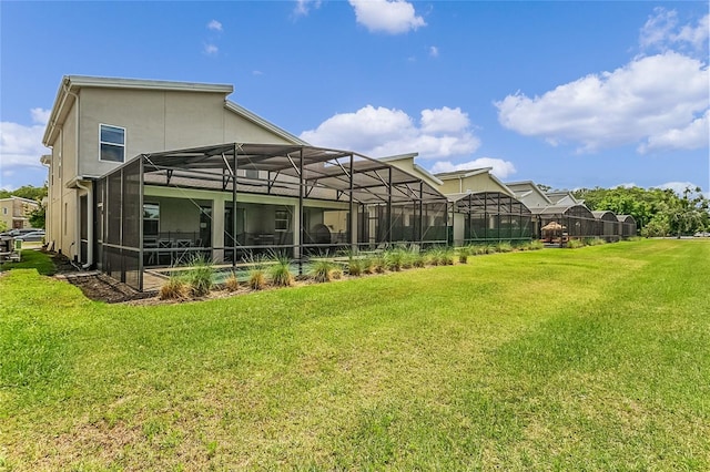 back of property with a lanai and a lawn