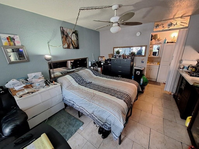 tiled bedroom with ensuite bath, ceiling fan, and a textured ceiling