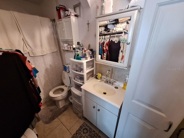 bathroom featuring tile flooring, toilet, and vanity