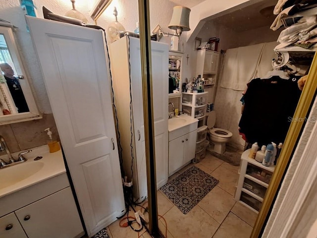 bathroom with tile flooring, vanity, and toilet