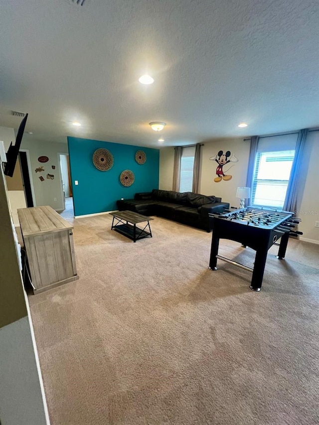 rec room featuring carpet flooring and a textured ceiling