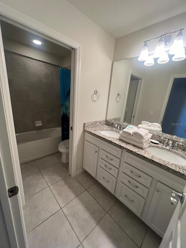 full bathroom featuring toilet, dual sinks, vanity with extensive cabinet space, and tile flooring