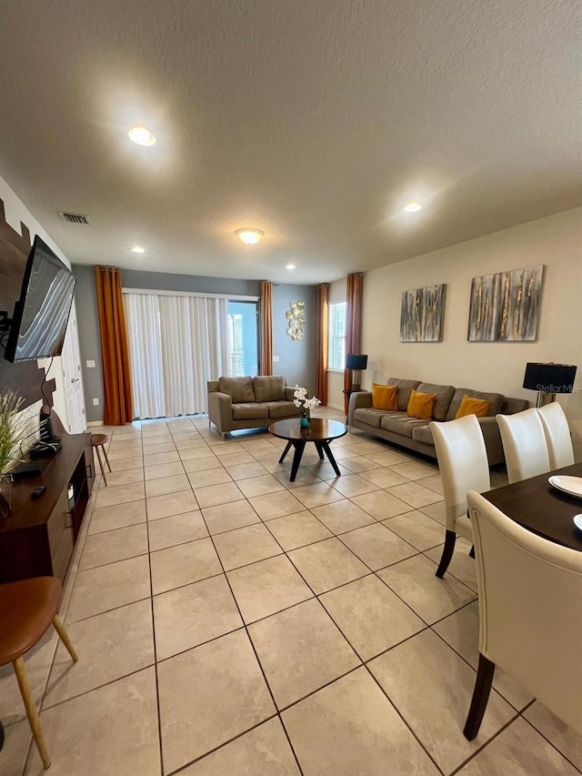 living room with light tile flooring and a textured ceiling