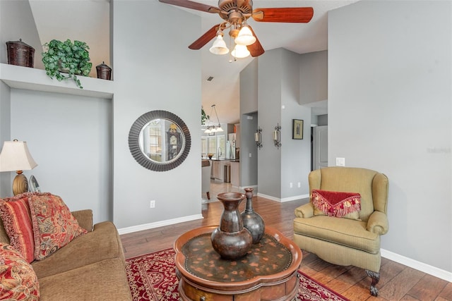 living room with wood-type flooring, ceiling fan, and high vaulted ceiling