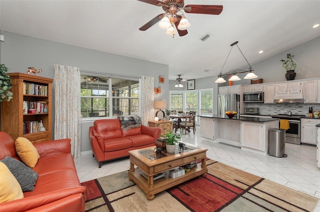 living room with lofted ceiling, a wealth of natural light, ceiling fan, and light tile floors