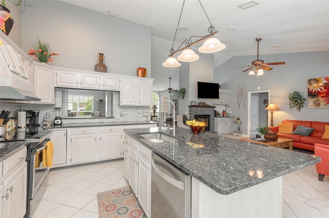 kitchen featuring high vaulted ceiling, appliances with stainless steel finishes, sink, tasteful backsplash, and an island with sink