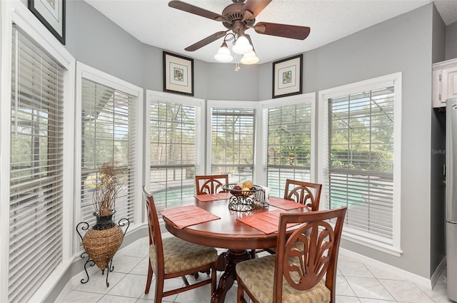 tiled dining room featuring plenty of natural light, ceiling fan, and a textured ceiling