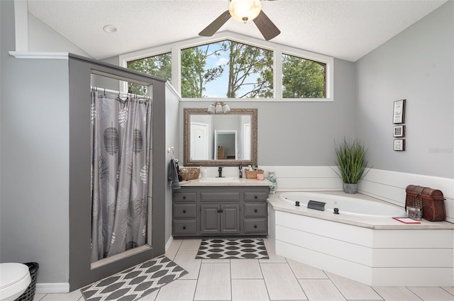 bathroom featuring vanity with extensive cabinet space, a textured ceiling, vaulted ceiling, and a bath