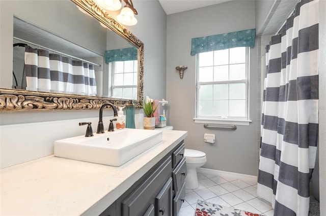 bathroom featuring plenty of natural light, toilet, and large vanity