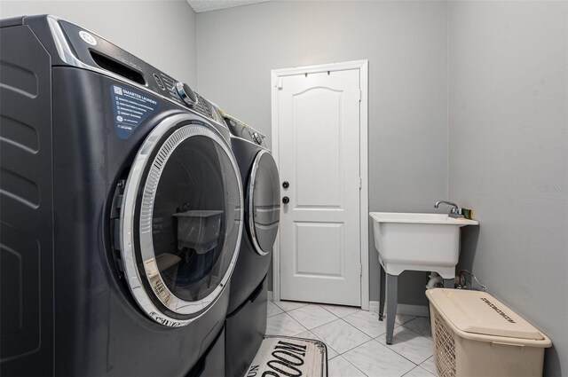 laundry room with washer and clothes dryer and light tile flooring