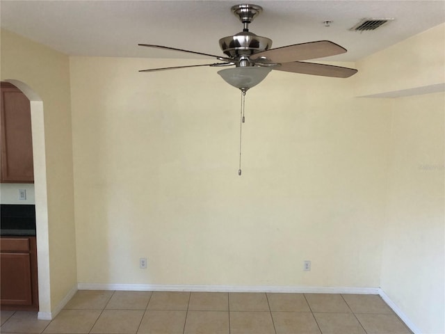 tiled empty room featuring ceiling fan