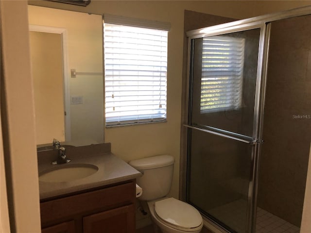 bathroom featuring walk in shower, vanity, and toilet