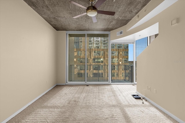 carpeted empty room featuring floor to ceiling windows and ceiling fan