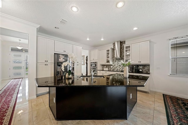 kitchen featuring appliances with stainless steel finishes, white cabinetry, a large island, and wall chimney exhaust hood