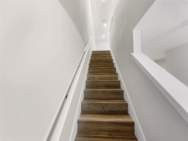 stairs featuring hardwood / wood-style floors