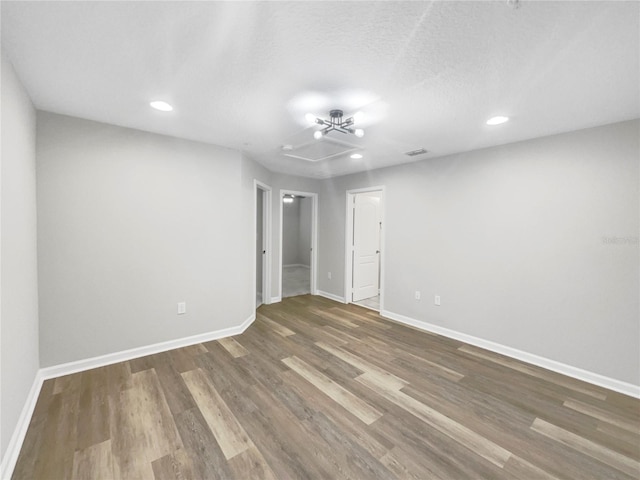 unfurnished room with wood-type flooring and a textured ceiling