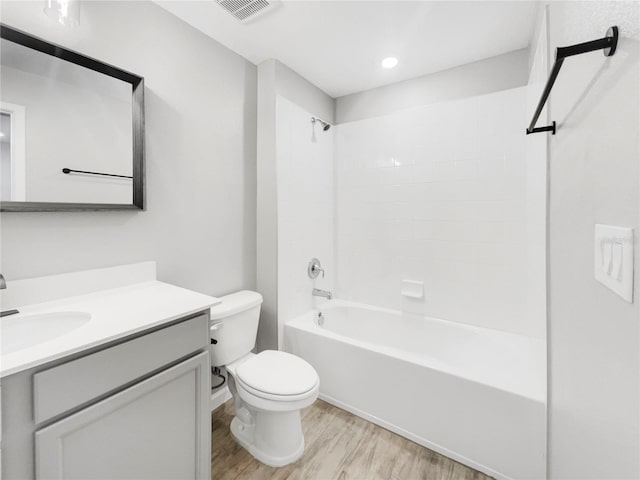 full bathroom featuring toilet, vanity, hardwood / wood-style floors, and shower / tub combination