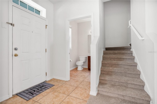 entrance foyer with stairs, baseboards, and light tile patterned floors