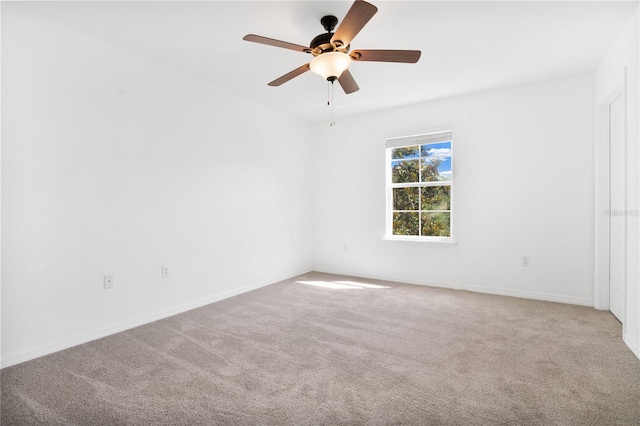 spare room featuring carpet floors, ceiling fan, and baseboards