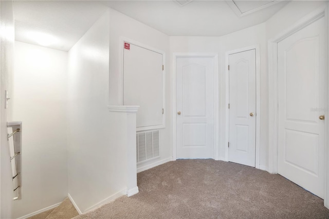 hall featuring carpet floors, baseboards, and visible vents