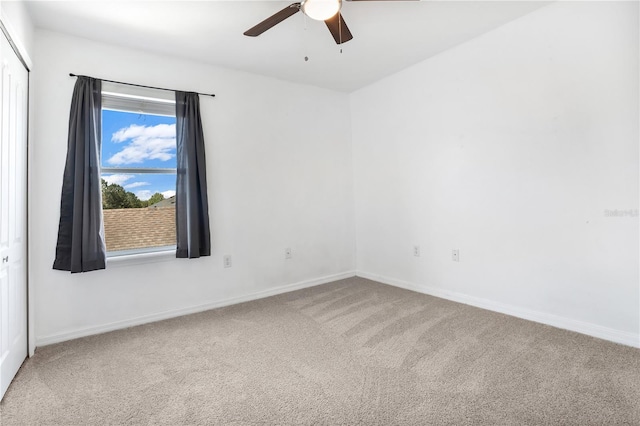 empty room featuring carpet floors, a ceiling fan, and baseboards