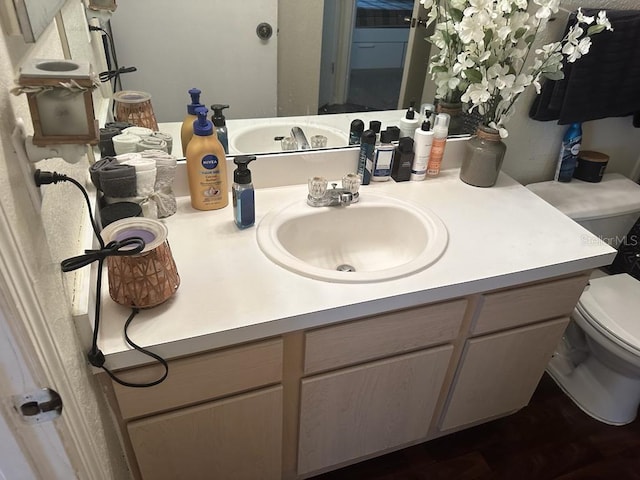 bathroom with vanity with extensive cabinet space and toilet