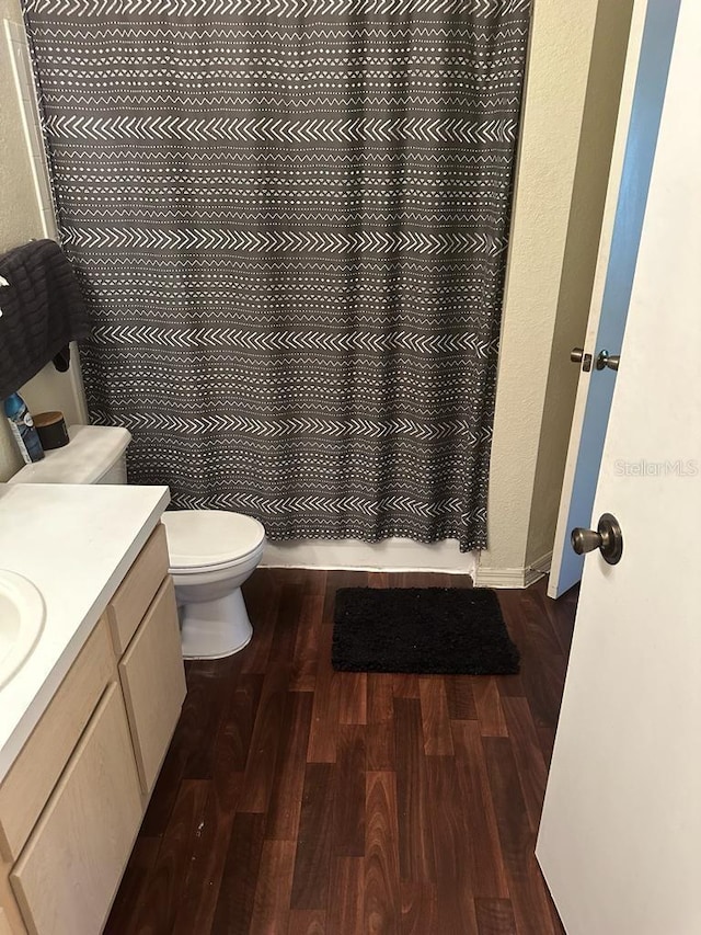 bathroom featuring hardwood / wood-style flooring, toilet, and vanity