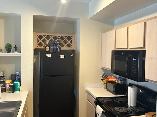 kitchen with sink, light brown cabinetry, and black appliances