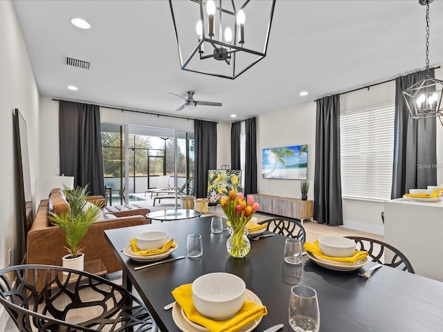 interior space with ceiling fan with notable chandelier and light hardwood / wood-style floors