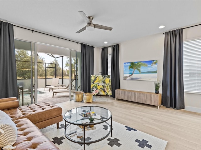 living room with light hardwood / wood-style flooring and ceiling fan