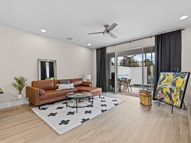 living room with light hardwood / wood-style flooring and ceiling fan