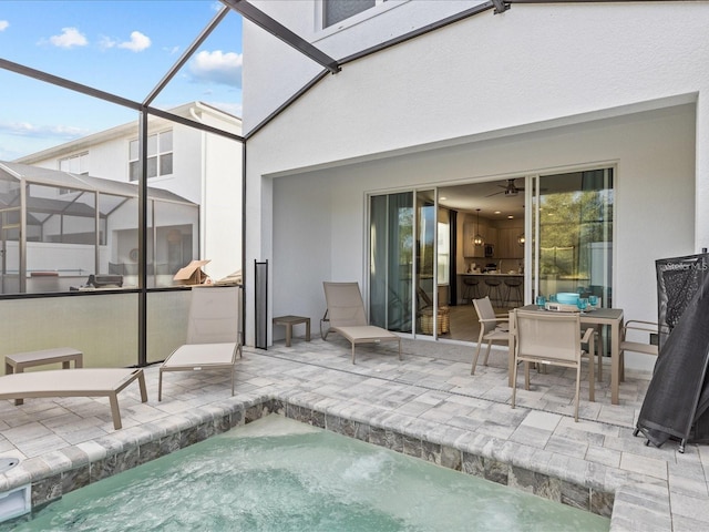 view of swimming pool with a patio, glass enclosure, and a hot tub