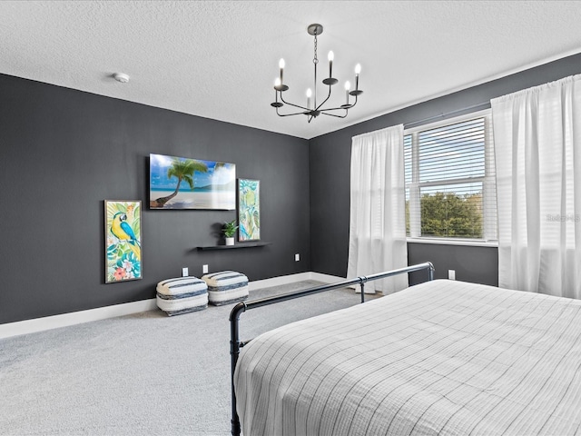 bedroom with a textured ceiling, a notable chandelier, and carpet flooring