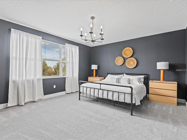 carpeted bedroom featuring a textured ceiling and an inviting chandelier