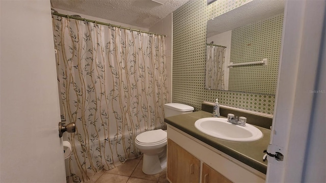 bathroom with toilet, tile flooring, vanity, and a textured ceiling