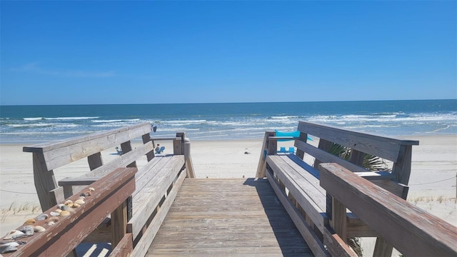 view of dock featuring a beach view and a water view