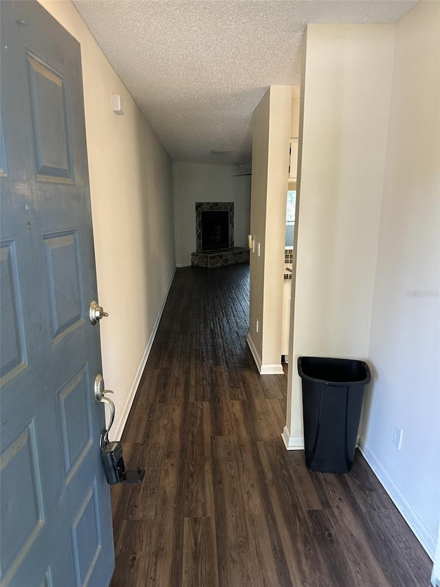 hallway with dark hardwood / wood-style flooring and a textured ceiling