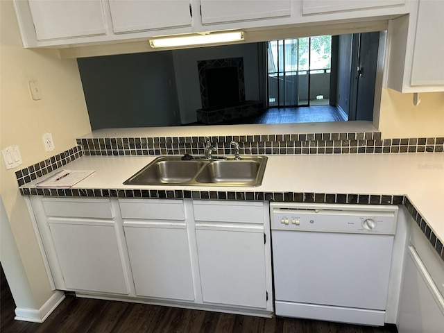 kitchen with white cabinets, dark hardwood / wood-style floors, sink, and white dishwasher