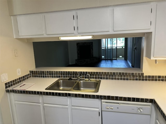 kitchen with backsplash, sink, white dishwasher, and white cabinetry