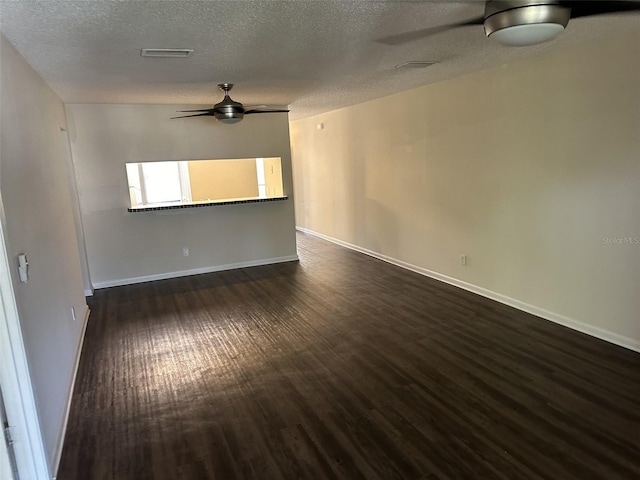 empty room featuring dark wood-type flooring, ceiling fan, and a textured ceiling